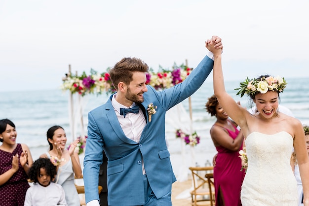 Recém-casados ​​alegres no casamento de praia