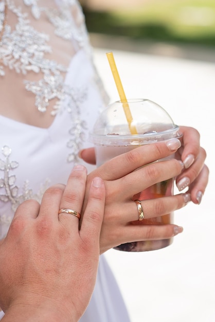 Recém-casados com coquetéis nas mãos closeup da mão e anel bebida de verão