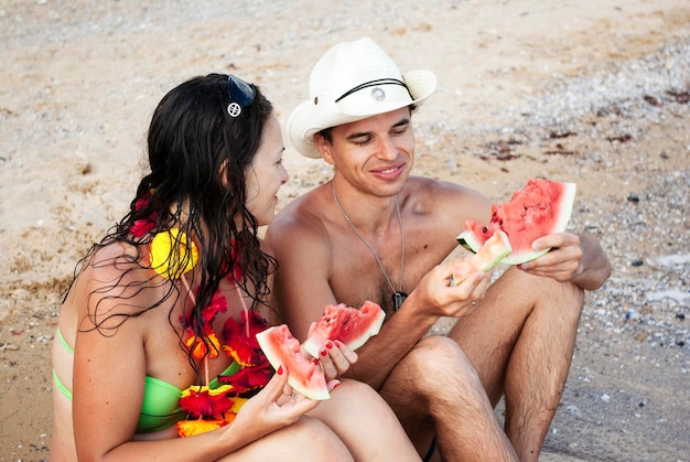 Recém-casados comem melancia na praia