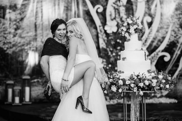 Recém-casados cortam alegremente, riem e provam o bolo de casamento