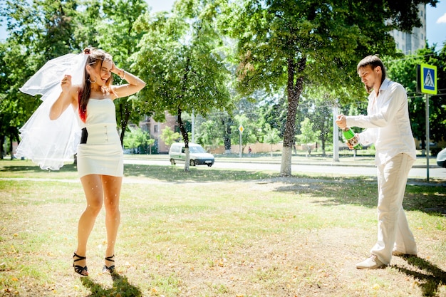 Recém-casados felizes celebrando casamento no parque.