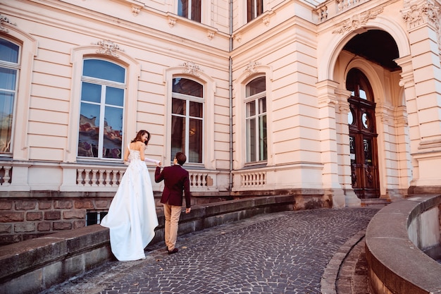 Recém-casados na entrada do palácio com uma arquitetura antiga