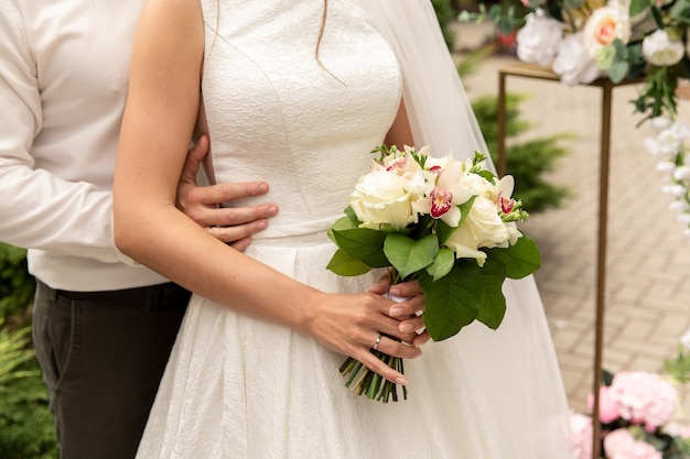 Recém-casados no dia do casamento, casal de noivos com buquê de flores, noiva e noivo