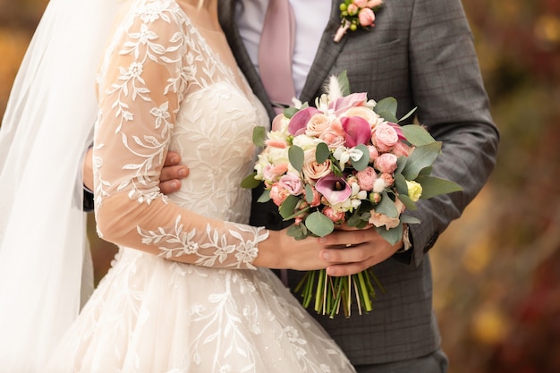 Foto recém-casados no dia do casamento, casal de noivos com buquê de flores, noiva e noivo