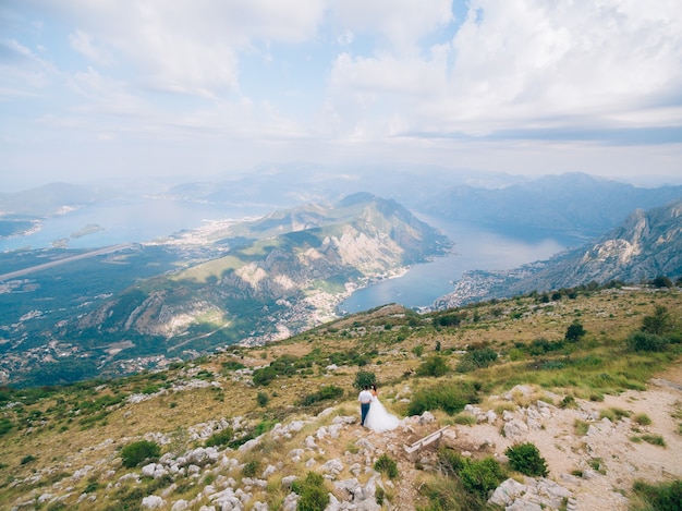 Recém-casados no monte lovcen admirando a vista