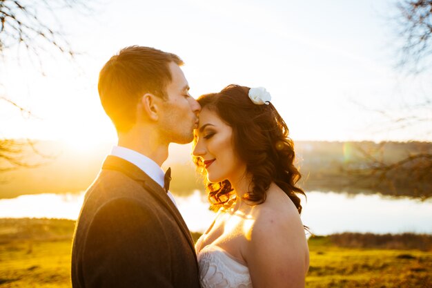 Recém-casados posando em um parque