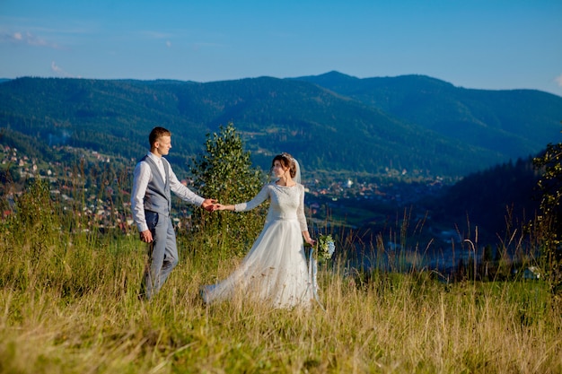 Recém-casados posando em um prado