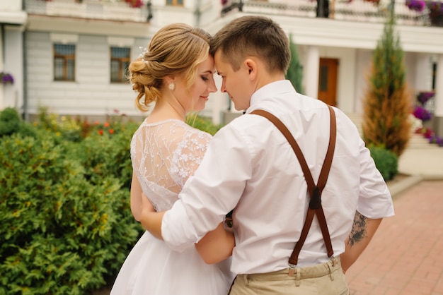 Recém-casados se divertem inclinando a cabeça um para o outro. Relacionamentos, concerto de amor.