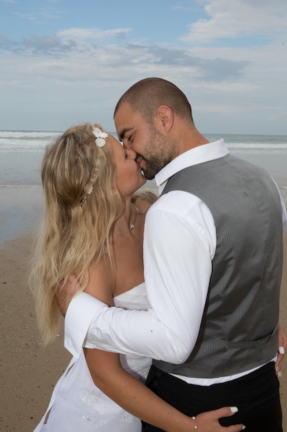 Recém-casal de casamento na praia apaixonado