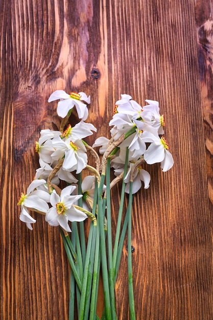 Recém-cortado bando de narcisos brancos em uma mesa de madeira. Copie o espaço.