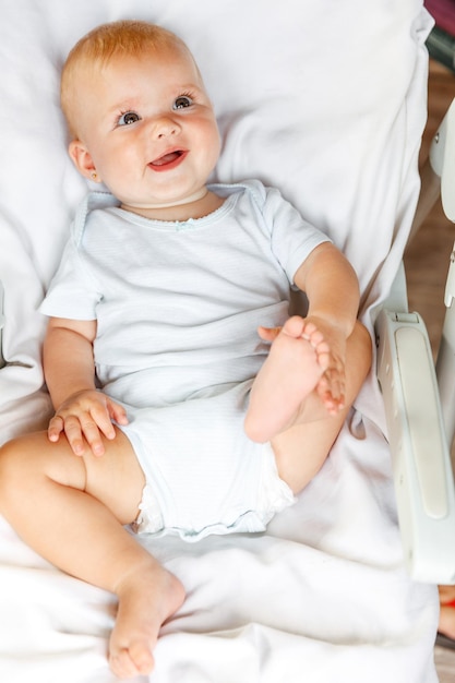 Recém-nascido menina bonitinha com rosto sorridente, olhando para a câmera no fundo branco infantil bebê descansando ...