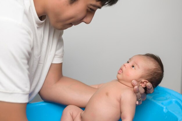 Recém-nascido tomando banho por feliz mãe e pai família e conceito de amor