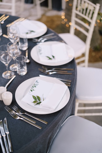 Recepção de mesa de jantar de casamento pratos redondos brancos em uma mesa redonda com toalha de mesa cinza branca