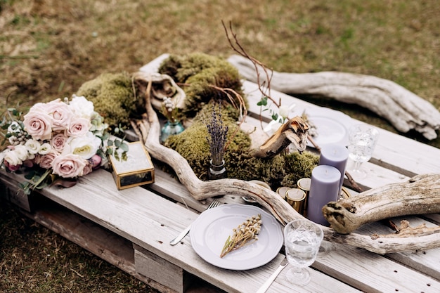 Recepção de mesa de jantar de casamento uma mesa improvisada para dois dos paletes de construção na grama cinza