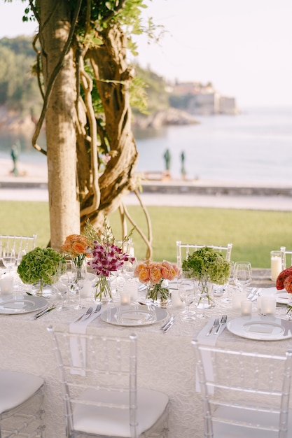 Recepção de mesa de jantar de casamento uma mesa muito longa para convidados com uma toalha de mesa branca floral