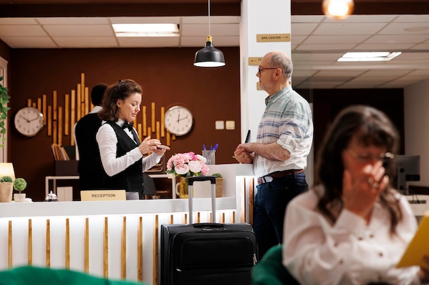 Recepcionista ayudando al huésped con el check-in