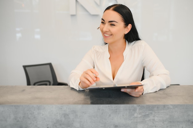 Recepcionista de mujer morena trabajando en la recepción del salón de belleza