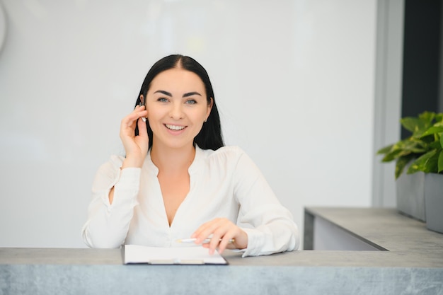 Recepcionista de mujer morena trabajando en la recepción del salón de belleza