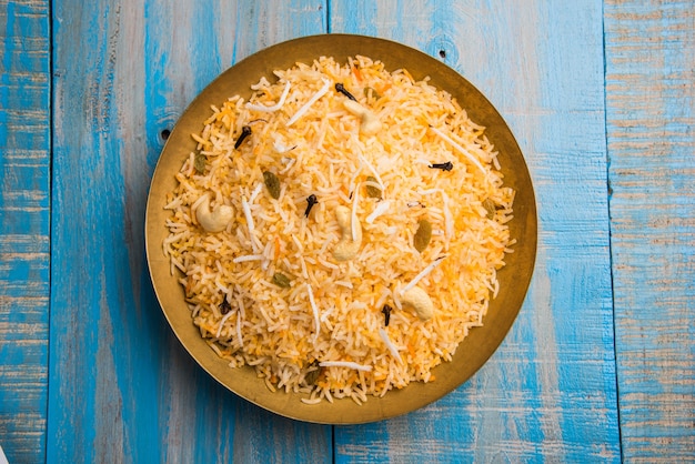 Receta de arroz dulce con coco también conocida como narali bhat hecha con azafrán, anacardo, clavo de olor y servida en un tazón blanco. Comida popular konkani o maharashtrian.