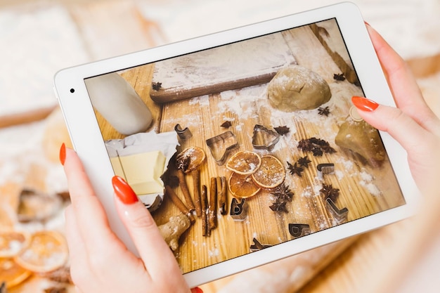 Receta culinaria en línea Vista superior de la pantalla de la tableta con ingredientes de pastelería Señora grabando los pasos para hacer galletas