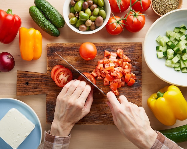 Receta paso a paso para ensalada horiatiki, tabla de madera para cortar verduras