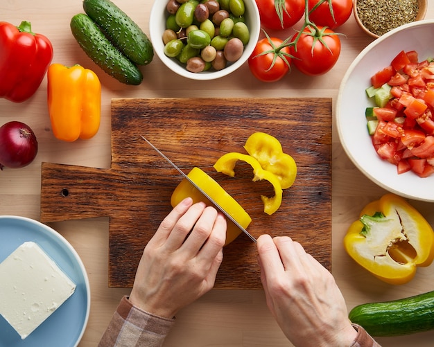 Receta paso a paso para ensalada horiatiki, tabla de madera para cortar verduras