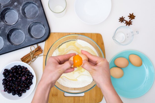 Receta paso a paso para muffins con grosellas negras. preparando la masa, mezclando los ingredientes de harina, mantequilla, azúcar, huevos, vainilla, grosella. La vista desde la cima. magdalenas con relleno de grosellas