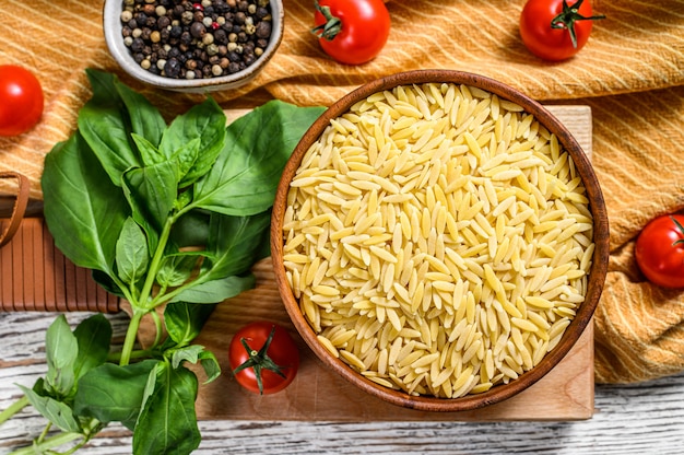 Receta de pasta de orzo cruda para risoni con hojas de albahaca, tomate y ajo