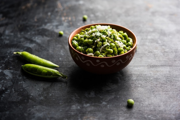 Receta seca de guisantes verdes o matar ki sookhi sabji, servida en una cacerola o tazón de terracota. Enfoque selectivo