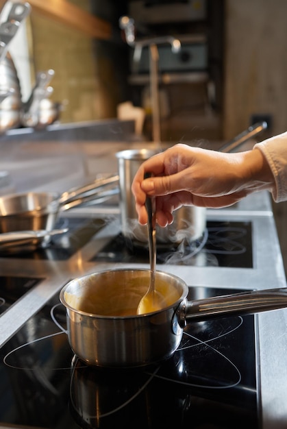 Receta de sopa de calabaza la mano del chef pone los ingredientes en la olla y cocina todo para acompañar la sopa