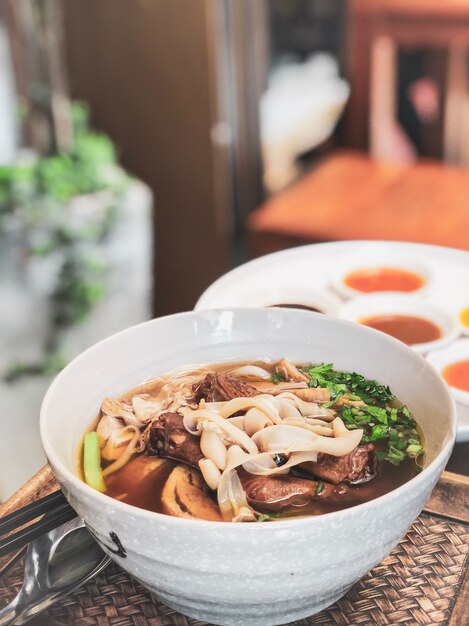 Receta de sopa de fideos de pato asado chino sobre mesa de madera