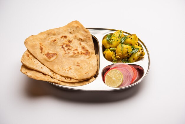 Receta de verduras de patata seca con pan plano del triángulo indio. Aloo sabji con tikona paratha o parantha. comida india