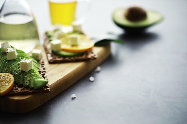 Recetas de cocina con aguacate. Aguacate verde maduro en una tabla de cortar de madera para servir.