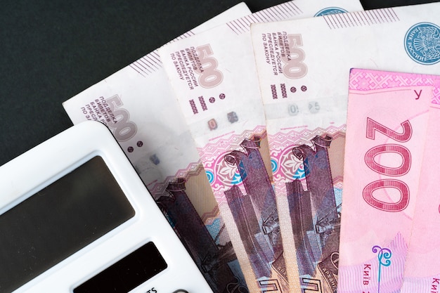 Rechner mit Haufen Geld ukrainische Griwna