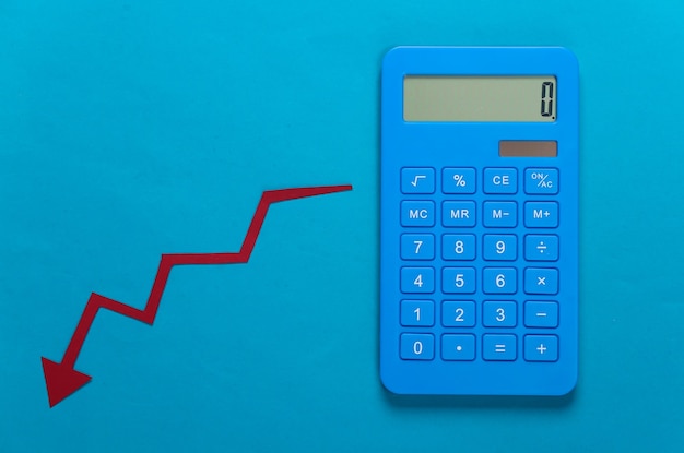 Rechner und roter Fallpfeil. Falldiagramm geht nach unten. Wirtschaftsrezession, Krise