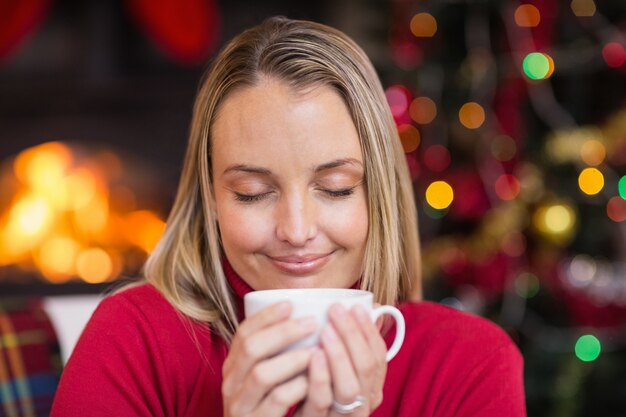 Recht blond, ein heißes Getränk am Weihnachten genießend