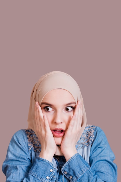 Foto recht entsetzte moslemische frau mit bedecktem kopf über studiohintergrund