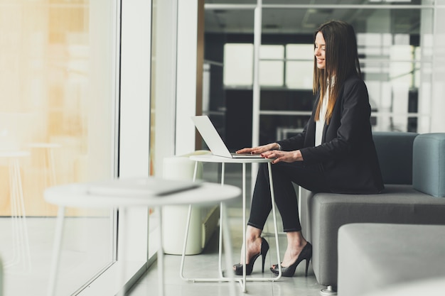 Recht junge Frau, die im Büro arbeitet