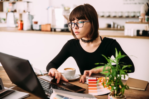 Recht junge Frau, die Laptop im Büro verwendet