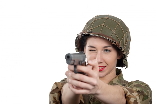 Recht junge Frau kleidete in der amerikanischen Militäruniform ww2 mit Sturzhelm und Pistole an