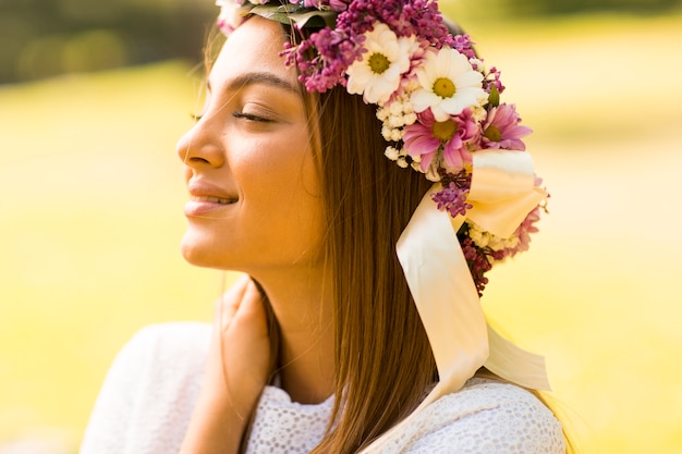 Recht junge Frau mit Blumen in ihrem Haar am sonnigen Frühlingstag