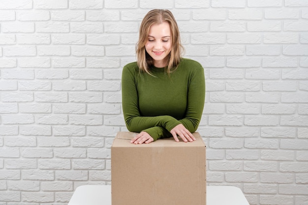 Foto recht junge frau mit paketkasten, der ein paket liefert