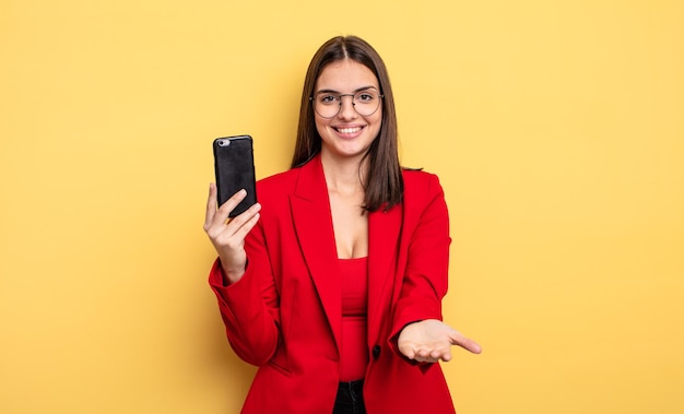 Recht junge Geschäftsfrau, die ein Telefon anhält