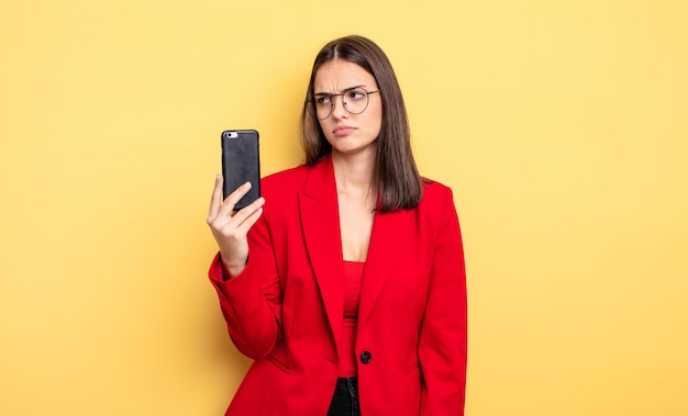 Recht junge Geschäftsfrau, die ein Telefon anhält