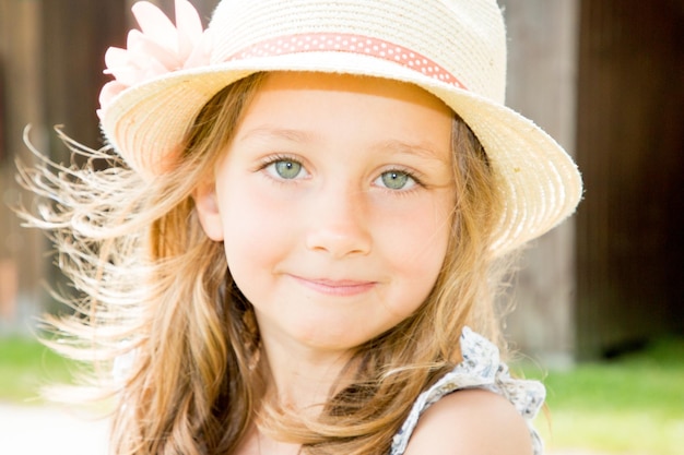 Recht junges Kindermädchen mit Hut am sonnigen Tag des Sommers