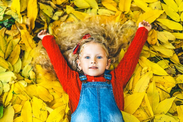 Recht kleines Mädchen haben Spaß im Park, Herbstzeit.