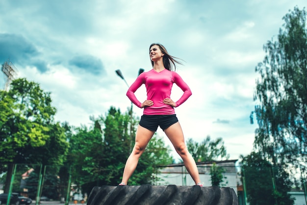 Recht sportliches Mädchentraining im Freien mit großem Reifen