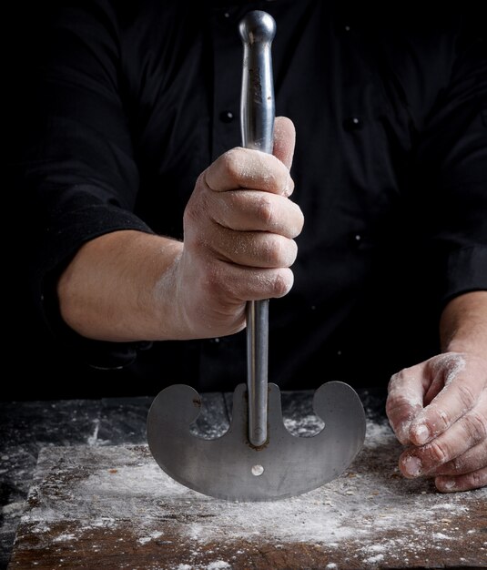 Rechte männliche Hand hält ein altes Metallküchenmesser