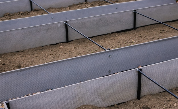 Rechteckige Betten im Garten mit eigenen Händen gemacht. Komfort beim Pflanzen von Pflanzen. Betten aus Schiefer und Metall.