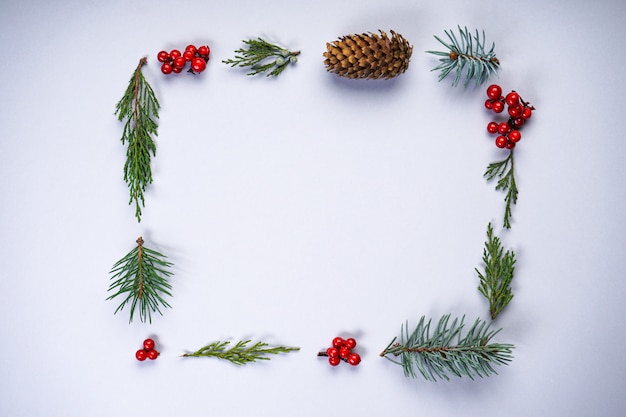 Rechteckiger Weihnachtsrahmen aus natürlichen Wintersachen auf Grau mit Copyspace, flache Lage